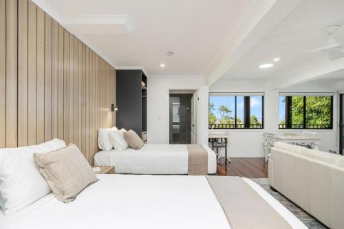 two beds in a room with a tub and a bathroom at Ocean Outlook Retreat in River Heads