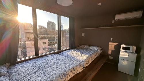 a bedroom with a bed and a large window at WINN hotel in Tokyo