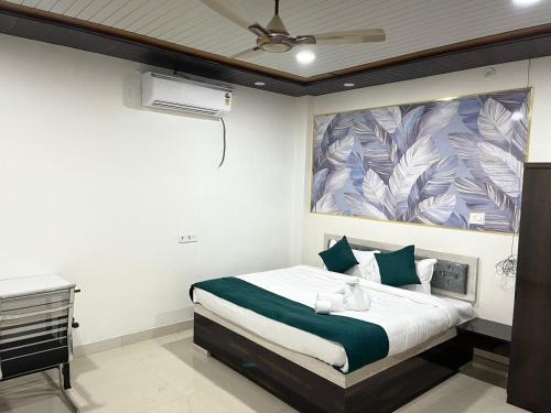 a bedroom with a bed with a painting on the wall at Hotel PSR INN in Mughal Sarāi
