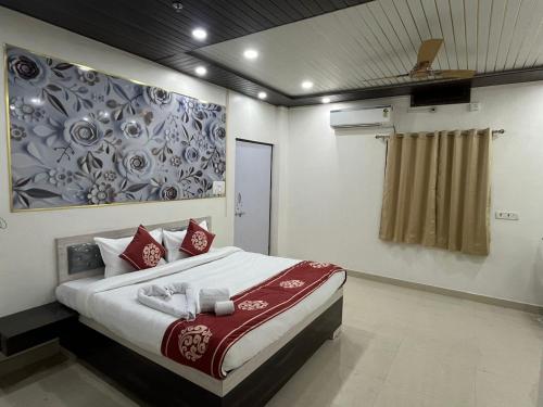 a bedroom with a large bed with a painting on the wall at Hotel PSR INN in Mughal Sarāi