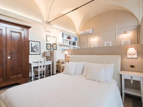 ヴェローナにあるSuite Prestige Veronaのベッドルーム(白い大型ベッド1台、デスク付)