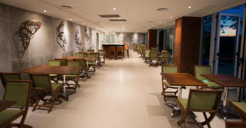 a row of tables and chairs in a restaurant at Hotel Guaminí Misión in Puerto Iguazú