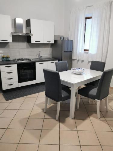 eine Küche mit einem weißen Tisch und Stühlen in einer Küche in der Unterkunft Civico56 in Patti