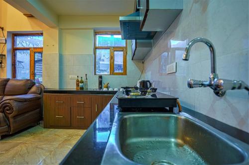 a kitchen with a large tub in a kitchen at Pine Wood Chalet in Manāli
