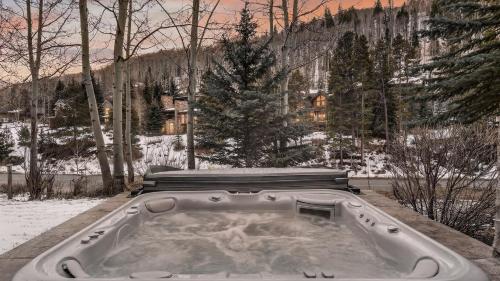 a hot tub in the snow next to a bench at Bergrose Lodge in Vail