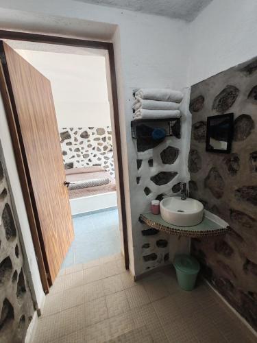 a bathroom with a sink and a door to a room at La gloria hospedajes in Cuernavaca