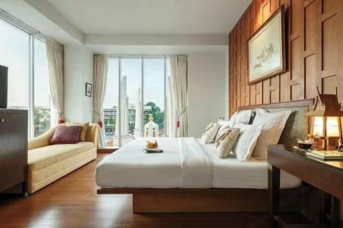 a large bedroom with a large bed and a couch at Collection O Dinso Home Boutique in Bangkok
