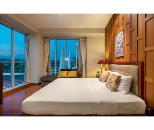 a bedroom with a large bed with a large window at Collection O Dinso Home Boutique in Bangkok