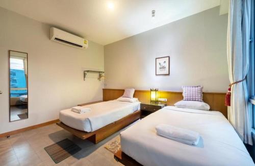 a hotel room with two beds and a mirror at Collection O Dinso Home Boutique in Bangkok