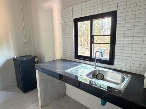 a kitchen with a sink and a window at I mee Lanta Home in Phra Ae beach