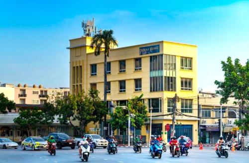 a group of people riding motorcycles in front of a yellow building at Collection O Dinso Home Boutique in Bangkok