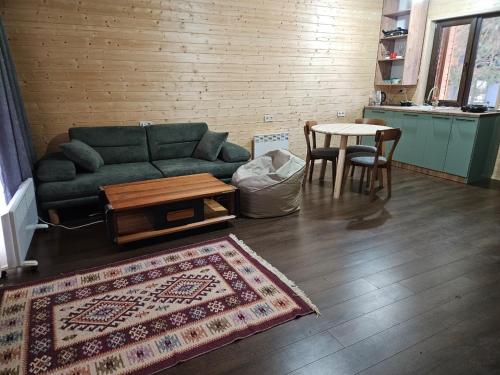 a living room with a couch and a table at Tatu's wooden hut in Mestia