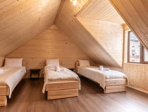 a room with two beds in a wooden attic at Tatu's wooden hut in Mestia