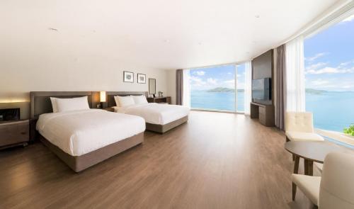 a hotel room with two beds and a view of the ocean at Venezia Hotel and Suite in Yeosu