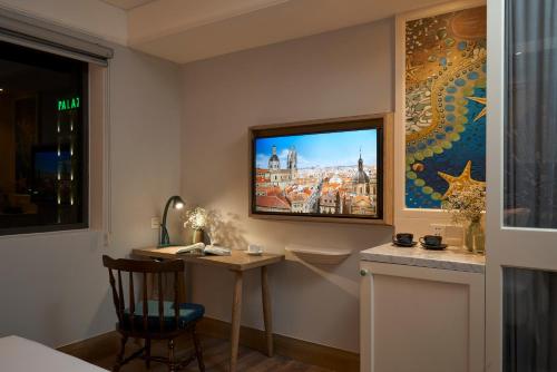 a room with a desk and a tv on the wall at Sofiana My Khe Hotel & Spa - Rooftop Pool Bar - Free 01 Draught Beer and 20-minute Spa per Room in Danang