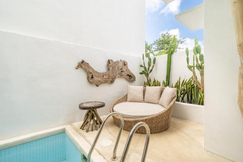 a wicker chair sits next to a swimming pool at Casa Sud - Secluded Pool Villa in Uluwatu in Uluwatu