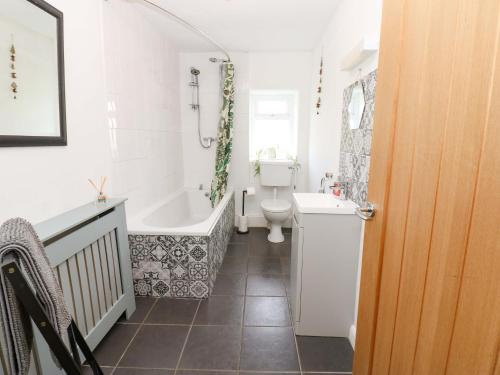 a bathroom with a tub and a toilet and a sink at The Hayloft in Ripon