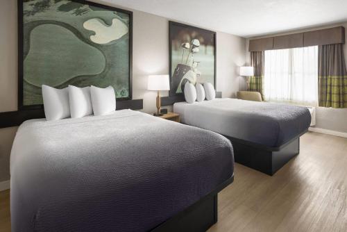 a hotel room with two beds and a window at Super 8 by Wyndham Ellenton Bradenton Area in Ellenton