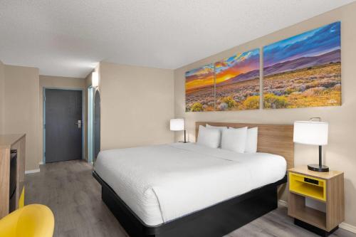 a hotel room with a bed and a tv at Days Inn & Suites by Wyndham Airport Albuquerque in Albuquerque