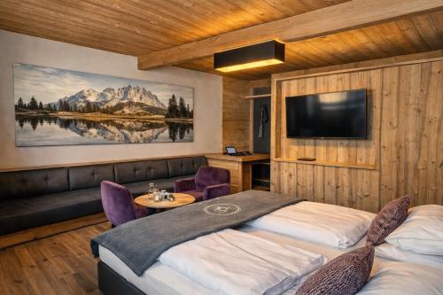 ein Schlafzimmer mit zwei Betten und einem Flachbildfernseher in der Unterkunft Der Postwirt in Söll