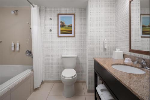 a bathroom with a toilet and a sink and a tub at Hampton Inn Augusta Fort Eisenhower in Augusta