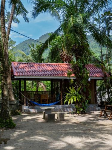 a house with a hammock in front of it at Bananas Resort & Restaurant in Tha Lane Bay