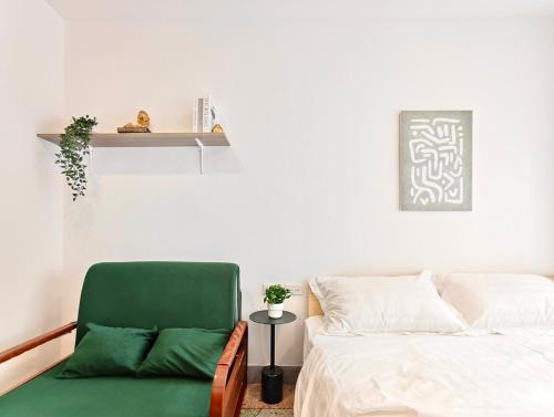 a bedroom with a green chair next to a bed at 8 Min Walk to IconSiam I BTS near Pier in Bangkok