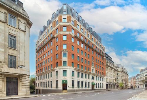 a tall red brick building on a city street at The Derby London City, Curio Collection By Hilton in London