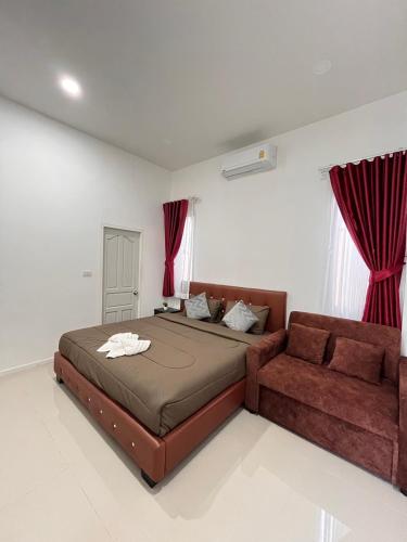 a bedroom with a bed and a couch at Cozy Poolvilla Pattaya in Bang Lamung