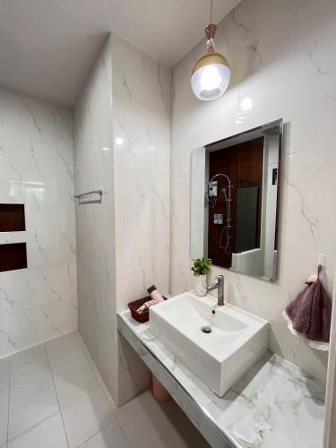 a white bathroom with a sink and a mirror at Cozy Poolvilla Pattaya in Bang Lamung
