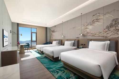 a row of beds in a hotel room at Wyndham Lijiang Yulong in Lijiang