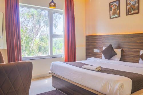 a bedroom with a large bed and a window at HOTEL HIVE in Mājra