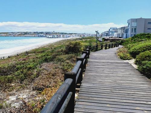 a wooden boardwalk leading down to the beach at Langebaan Beach Towers in Langebaan