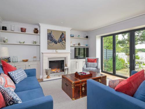 ein Wohnzimmer mit blauen Sofas und einem Kamin in der Unterkunft Tarn End in Brampton