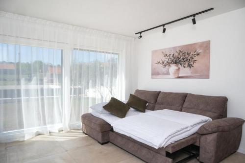a living room with a couch and a large window at Casa Mia in Danilo Biranj