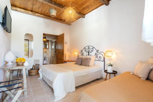 a bedroom with two beds and a tv in a room at Masseria Capricella in Fasano