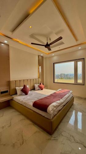 a bedroom with a large bed with a ceiling fan at HOTEL RR Grand in Varanasi