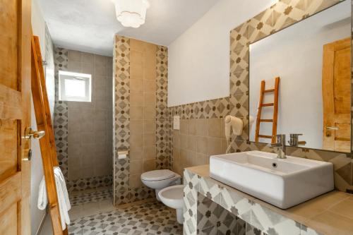 a bathroom with a sink and a toilet at Masseria Capricella in Fasano
