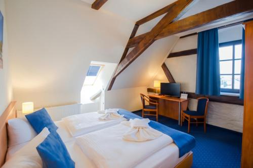 a hotel room with a bed and a desk at Gasthaus Zum Schwan in Oschatz
