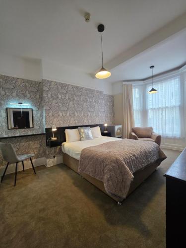 a bedroom with a large bed and a chair at Rivelyn Hotel Bar & Restaurant in Scarborough