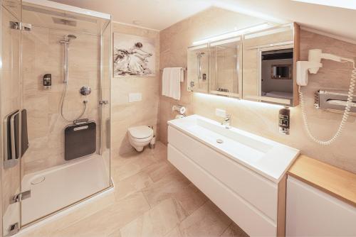a bathroom with a sink and a shower and a toilet at Hotel Kufsteinerhof in Kufstein