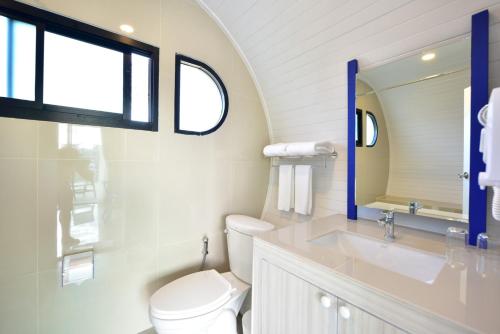 ein Badezimmer mit Toilette, Waschbecken und Spiegel in der Unterkunft Krabi Boat Lagoon Resort in Krabi