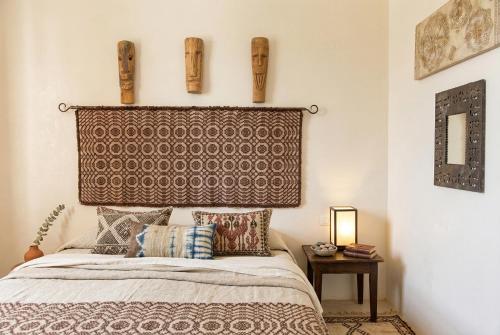 a bedroom with a bed with a headboard and pillows at ClickSardegna Villa Emanuel spectacular sea view, with independent swimming pool in Alghero
