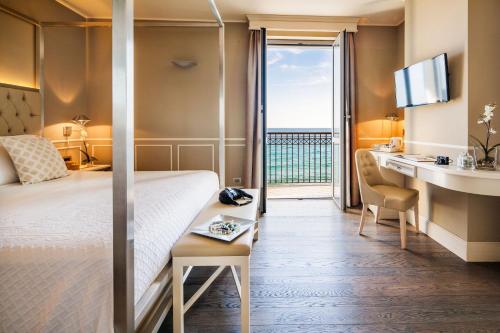 a hotel room with a bed and a balcony at Hotel Savoia in Alassio