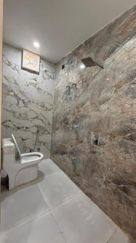 a bathroom with a toilet and a stone wall at HOTEL RR Grand in Varanasi
