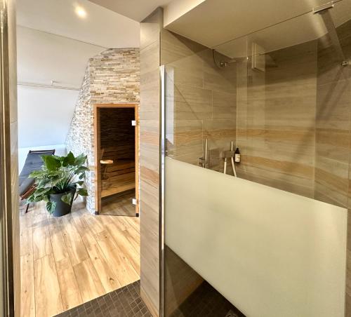 a room with a stone wall and a glass door at THE GOOD ONE Hotel Landshut in Landshut