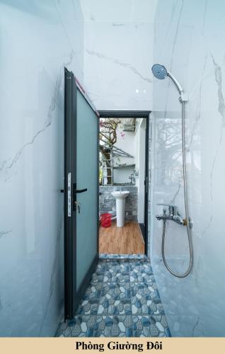 a bathroom with a shower and a glass door at Green Homestay in Danang