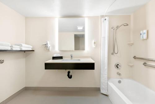a white bathroom with a sink and a bath tub at Comfort Inn Chula Vista San Diego South in Chula Vista