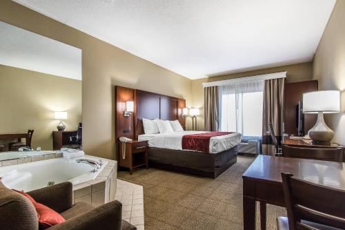 a hotel room with a bed and a bath tub at Comfort Suites Effingham Central in Effingham