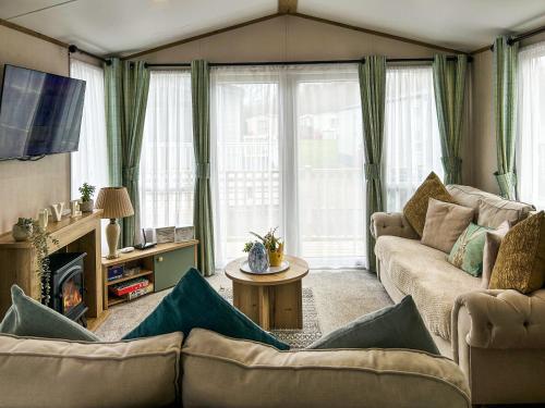 a living room with a couch and a tv at Seren - Uk51711 in Cockermouth